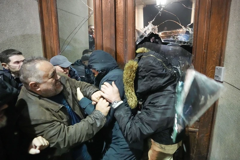 Opposition supporters attempt to enter the capital's city council building in protest of what election observers said were widespread vote irregularities during a general election last weekend in Belgrade, Serbia, Sunday, Dec. 24, 2023. The country's populist authorities have denied rigging the vote. President Aleksandar Vucic said Sunday that those claims were blatant "lies" promoted by the political opposition. (AP Photo/Darko Vojinovic)