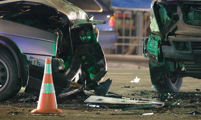 Damaged in heavy car accident vehicles after collision on city street crash site at night. Road safety and insurance concept. (Bilanol, Getty Images)