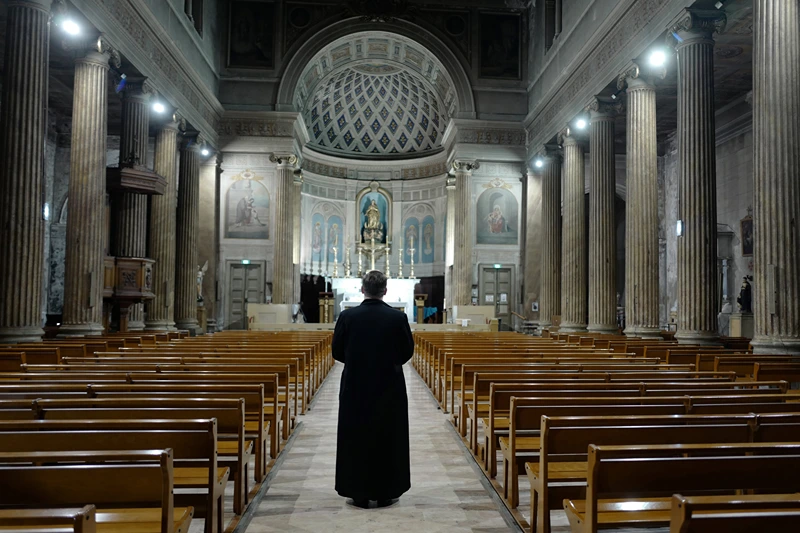 TOPSHOT-FRANCE-HEALTH-VIRUS TOPSHOT - A priest prays in the French Riviera city of Nice, southern France, on March 27, 2020 as a strict lockdown is extended to stop the spread of the COVID-19 in the country. (Photo by VALERY HACHE / AFP) (Photo by VALERY HACHE/AFP via Getty Images)