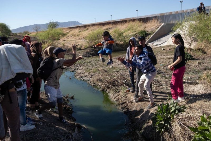 TOPSHOT - Migrants cross the Bravo river seen from the Mexican side of the US-Mexico border in Ciudad Juarez, Chihuahua state, Mexico, on March 29, 2023. - About 200,000 people try to cross the border from Mexico into the United States each month, most of them fleeing poverty and violence in Central and South America. (Photo by Guillermo Arias / AFP) (Photo by GUILLERMO ARIAS/AFP via Getty Images)