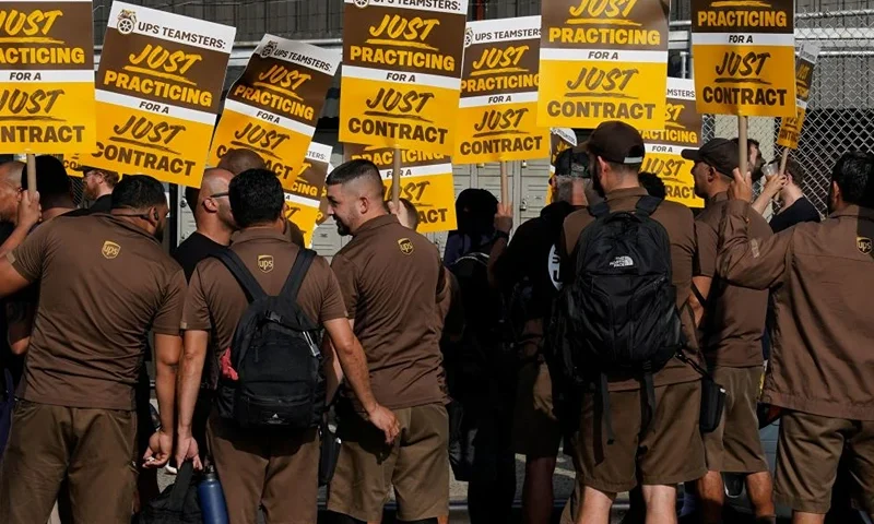 TOPSHOT - United Parcel Services (UPS) workers walk a 'practice picket line' on July 7, 2023, in the Queens borough of New York City, ahead of a possible UPS strike. UPS workers could go on strike by the end of July after the Teamsters Union, representing more than 300,000 UPS drivers and and warehouse workers, announced July 5, labor talks with the shipping giant broke down. (Photo by TIMOTHY A. CLARY / AFP) (Photo by TIMOTHY A. CLARY/AFP via Getty Images)