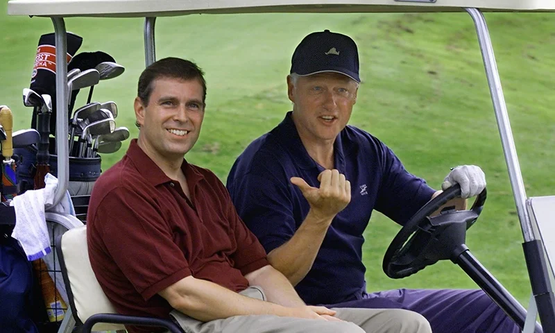 MARTHA'S VINEYARD, UNITED STATES: US President Bill Clinton (R) points his thumb to Great Britian's Prince Andrew (L) as they head off for a round of golf at the Farm Neck Golf Club 27 Aug 1999 in Martha's Vineyard. The two made a joking wager for the return of the island which was acquired by the US from Great Britian. (ELECTRONIC IMAGE) AFP PHOTO/Paul J. RICHARDS (Photo credit should read PAUL J. RICHARDS/AFP via Getty Images)
