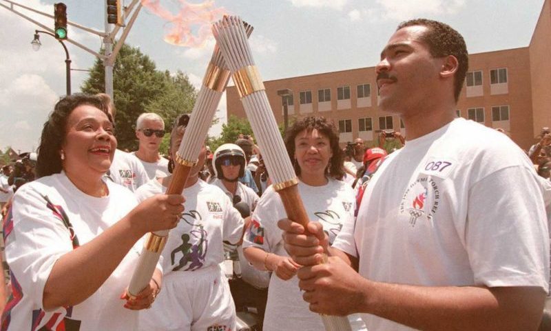 ATLANTA, GA - JULY 19: Coretta Scott King (L), widow of civil rights leader Martin Luther King, passes the Olympic Flame to her son Dexter Scott King 19 July in Atlanta. The Kings were part of a relay taking the flame around Atlanta before the opening ceremonies later 19 July. (for editorial use only) (Photo credit should read MICHEL GANGNE/AFP via Getty Images)