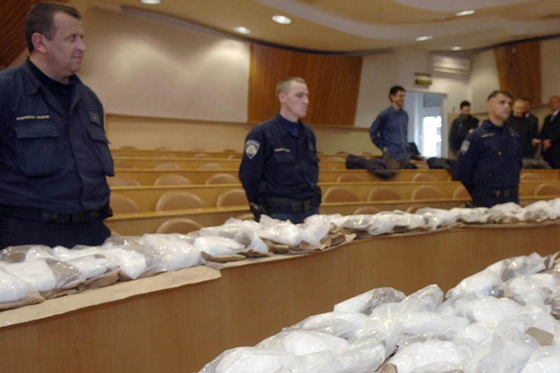 Croatian policemen guard some 160 kilos
Croatian policemen guard some 160 kilos of cocaine before showing it at a press conference in Zagreb, 28 November 2007. A south-European network of cocaine smugglers from Ecuador was dismantled and more than 160 kilos of drugs intended for a Bosnian company, were seized by the Croatian and Greek police forces, Croatian police announced 28 November. The drug, whose value was estimated at approximately 11 million euros, was seized in September and October in two intercepted containers of transport one with the Croatian port of Rijeka and the other with the Greek port of Pir?e, close to Athens. AFP PHOTO / Denis Lovrovic (Photo credit should read DENIS LOVROVIC/AFP via Getty Images)