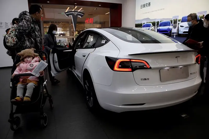 Visitors check a Tesla Model 3 car at a showroom of the U.S. electric vehicle (EV) maker in Beijing, China February 4, 2023. REUTERS/Florence Lo/File Photo