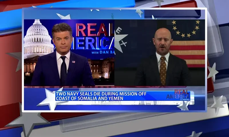 Video still from Real America on One America News Network showing a split screen of the host on the left side, and on the right side is the guest, Mike Sarraille.