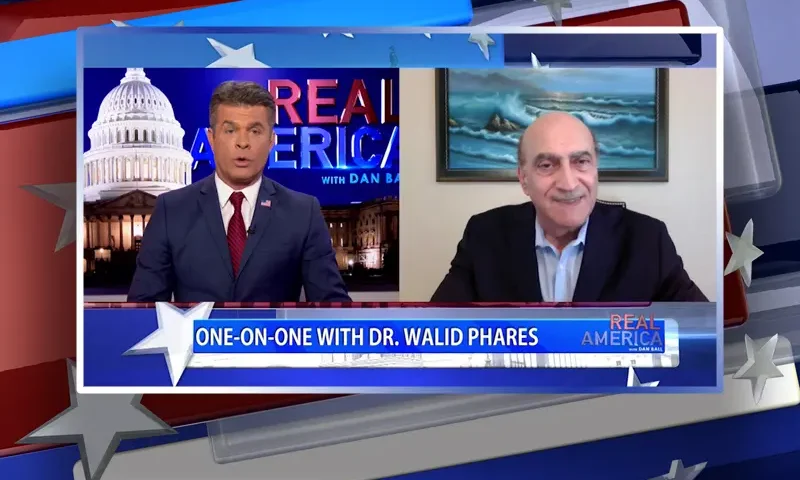 Video still from Real America on One America News Network showing a split screen of the host on the left side, and on the right side is the guest, Dr. Walid Phares.