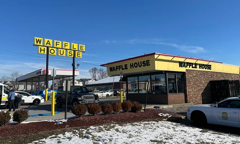 Police cars are shown near a Waffle House in Indianapolis Monday, Feb. 19, 2024, where at least one person was killed and several injured. (AP Phoot/Isabella Volmert)