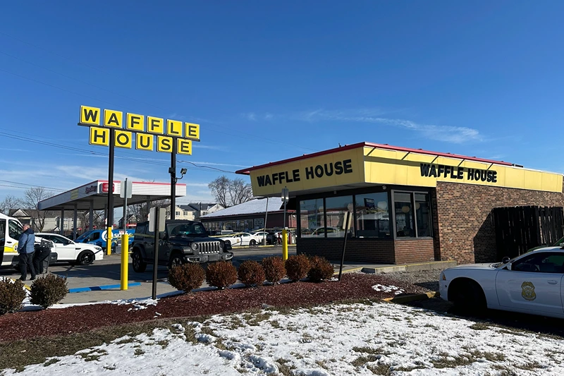 Police cars are shown near a Waffle House in Indianapolis Monday, Feb. 19, 2024, where at least one person was killed and several injured. (AP Phoot/Isabella Volmert)