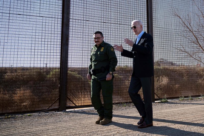 US President Joe Biden (L) speaks with a member of the US Border Patrol as they walk along the US-Mexico border fence in El Paso, Texas, on January 8, 2023. - Biden went to the US-Mexico border on Sunday for the first time since taking office, visiting an El Paso, Texas entry point at the center of debates over illegal immigration and smuggling. (Photo by Jim WATSON / AFP) (Photo by JIM WATSON/AFP via Getty Images)
