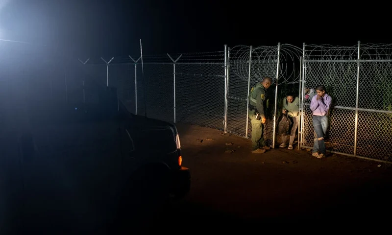 EAGLE PASS, TEXAS - MAY 22: A Border Patrol officer opens a gate for migrants from Colombia after they crossed the Rio Grande into the U.S. on May 22, 2022 in Eagle Pass, Texas. Title 42, the controversial pandemic-era border policy enacted by former President Trump, which cites COVID-19 as the reason to rapidly expel asylum seekers at the U.S. border, was set to officially expire on May 23rd. A federal judge in Louisiana delivered a ruling blocking the Biden administration from lifting Title 42. (Photo by Brandon Bell/Getty Images)