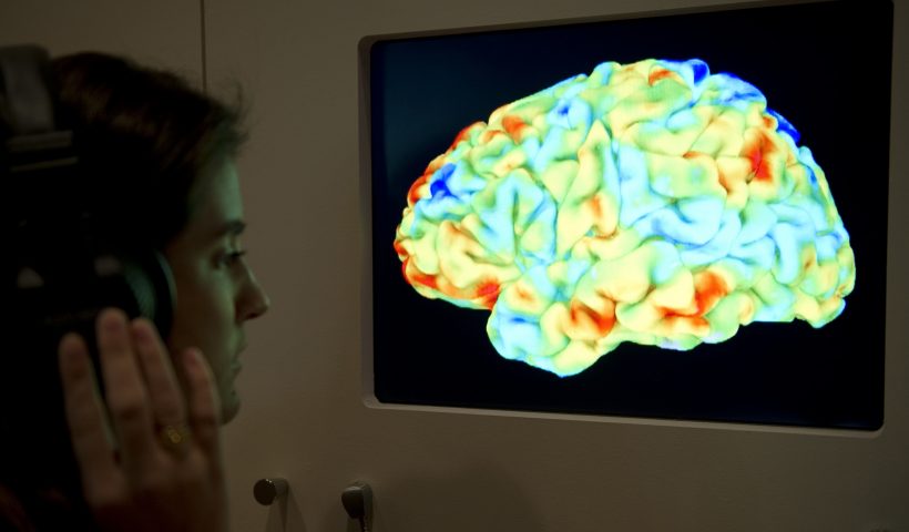 A woman looks at a functional magnetic resonance image (fMRI) showing the effect of Stravinsky's Rite of Spring and Kant's 3rd Critique on the human brain during the Wellcome Collection's major new exhibition "Brains: mind of matter" in London on March 27, 2012. AFP PHOTO / MIGUEL MEDINA (Photo credit should read MIGUEL MEDINA/AFP via Getty Images)