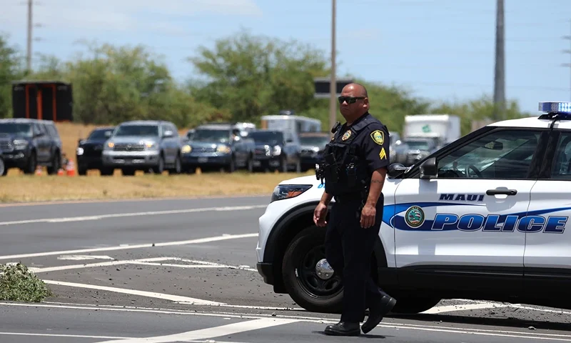 WAILUKU, HAWAII - AUGUST 11: A Maui police officer monitors traffic on the Honoapiilani highway as cars back up for miles before residents are allowed back into areas affected by the recent wildfire on August 11, 2023 in Wailuku, Hawaii. Dozens of people were killed and thousands were displaced after a wind-driven wildfire devastated the town of Lahaina on Tuesday. Crews are continuing to search for missing people. (Photo by Justin Sullivan/Getty Images)