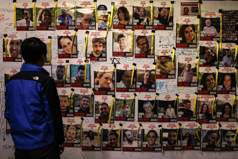 TOPSHOT - A man looks at posters bearing the images of Israeli hostages held in Gaza since the October 7 attack on the sidelines of a demonstration calling for their release, in Tel Aviv on December 2, 2023. Israel and Hamas brushed off international calls to renew an expired truce on December 2 as air strikes pounded militant targets in Gaza and Palestinian groups launched volleys of rockets. (Photo by AHMAD GHARABLI / AFP) (Photo by AHMAD GHARABLI/AFP via Getty Images)