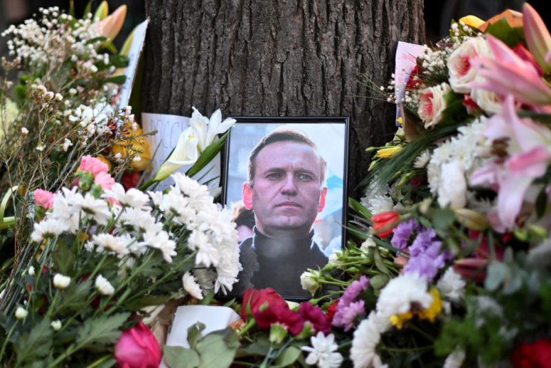 This photograph taken on February 16, 2024, shows a portrait of Alexei Navalny displayed amongst flowers as protestors pay their respects outside the Russian Embassy in Belgrade, following the news of Russian opposition leader and political activist Alexei Navalny's death at the Arctic prison where he was serving a 19-year-term. (Photo by OLIVER BUNIC / AFP) (Photo by OLIVER BUNIC/AFP via Getty Images)