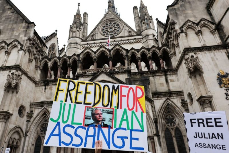 A demonstrator holds a placard reading "Freedom for Julian Assange" during a protest outside of the Royal Courts of Justice, Britain's High Court, in central London on February 21, 2024, on the second day of a UK appeal by WikiLeaks founder Julian Assange against his extradition to the US. Lawyers for the United States on Wednesday urged a UK court to block a last-ditch bid by Julian Assange to appeal his extradition there to face espionage charges. (Photo by Adrian DENNIS / AFP) (Photo by ADRIAN DENNIS/AFP via Getty Images)