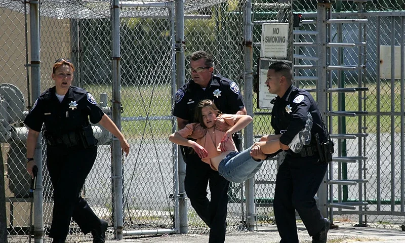 ALAMEDA, CA - MAY 22: Alameda Police officers carry a volunteer student with simulated injuries during a school shooting and mass evacuation drill at Lincoln Middle School May 22, 2007 in Alameda, California. The Alameda Police department in collaboration with the Alameda Fire department and the Alameda Unified School District conducted a drill simulating a school shooting situation with multiple gunmen and hostages. The mock disaster drill was planned a year ago, before the Virginia Tech shootings occurred. (Photo by Justin Sullivan/Getty Images)