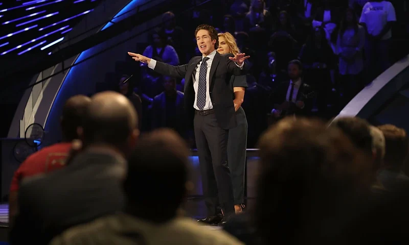 HOUSTON, TX - SEPTEMBER 03: Joel Osteen, the pastor of Lakewood Church, stands with his wife, Victoria Osteen, as he conducts a service at his church as the city starts the process of rebuilding after severe flooding during Hurricane and Tropical Storm Harvey on September 3, 2017 in Houston, Texas. Pastor Osteen drew criticism after initially not opening the doors of his church to victims of Hurricane Harvey. Harvey, which made landfall north of Corpus Christi on August 25, dumped around 50 inches of rain in and around areas of Houston and Southeast Texas. (Photo by Joe Raedle/Getty Images)
