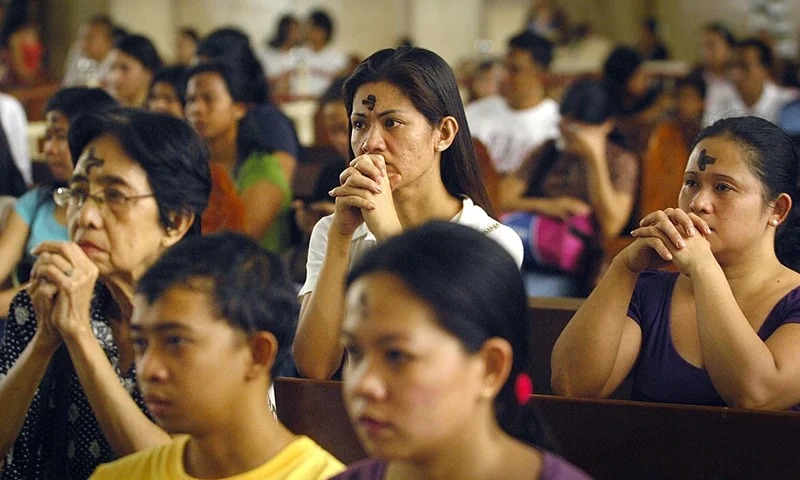 Filipino Catholics pray with the symbol of the cross written on their foreheads inside a church in Manila on February 25, 2009, as the country marks Ash Wednesday, the official beginning of the Christian Lenten season. The ash symbolizes the mortality of human beings, of bodies disintegrating to ash after one dies. The Philippines is Asia's bastion of Catholicism, with over 80 percent of the 86 million population belonging to the faith. AFP PHOTO/JES AZNAR (Photo credit should read JES AZNAR/AFP via Getty Images)