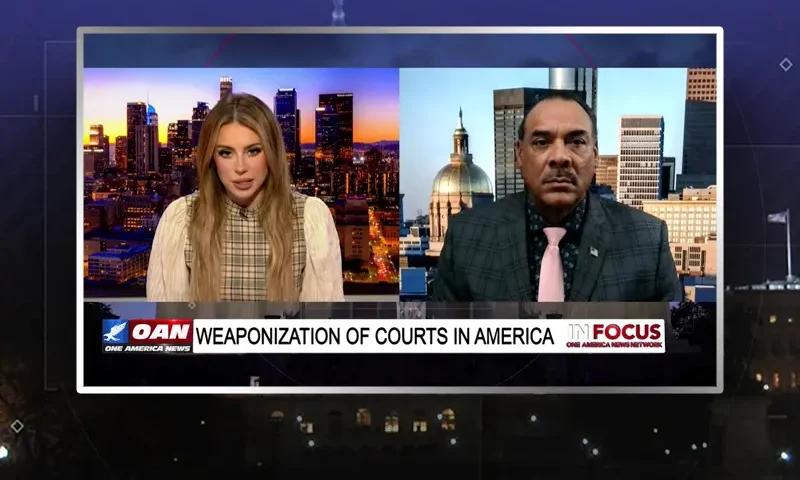 Video still from In Focus on One America News Network showing a split screen of the host on the left side, and on the right side is the guest, Bruce Levell.