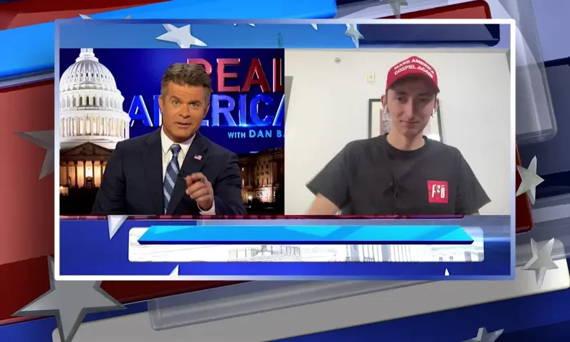 Video still from Real America on One America News Network showing a split screen of the host on the left side, and on the right side is the guest, Maison DesChamps.