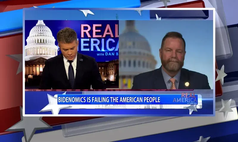 Video still from Real America on One America News Network showing a split screen of the host on the left side, and on the right side is the guest, Rep. Aaron Bean.