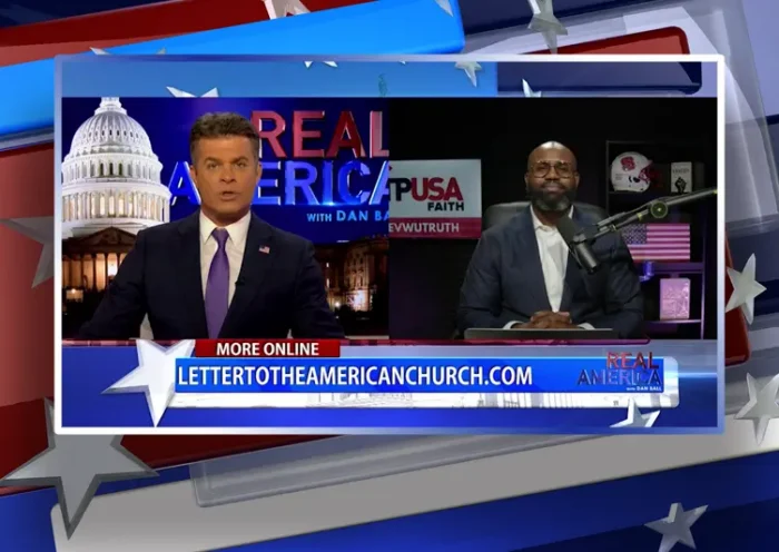 Video still from Real America on One America News Network showing a split screen of the host on the left side, and on the right side is the guest, John Amanchukwu.