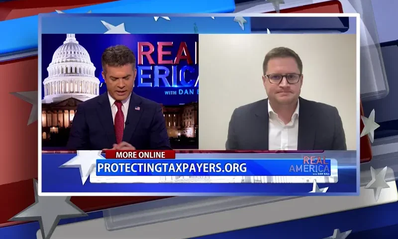 Video still from Real America on One America News Network showing a split screen of the host on the left side, and on the right side is the guest, Patrick Hedger.