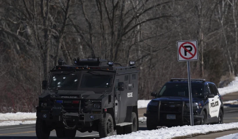 A police vehicle with what appears to be bullet pockmarks on its windshield is parked near the scene where two police officers and a first responder were shot and killed Sunday, Feb. 18, 2024, in Burnsville, Minn. (AP Photo/Abbie Parr)