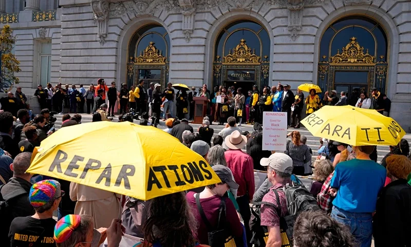 People listen during a rally in support of reparations for African Americans outside City Hall in San Francisco, Sept. 19, 2023. Eric Risberg/AP