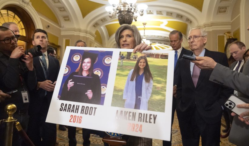 Sen. Joni Ernst, R-Iowa, holds a poster with photos of murder victims Sarah Root and Laken Riley as she speaks speaks after a policy luncheon on Capitol Hill, Tuesday, Feb. 27, 2024, in Washington. (AP Photo/Mark Schiefelbein)