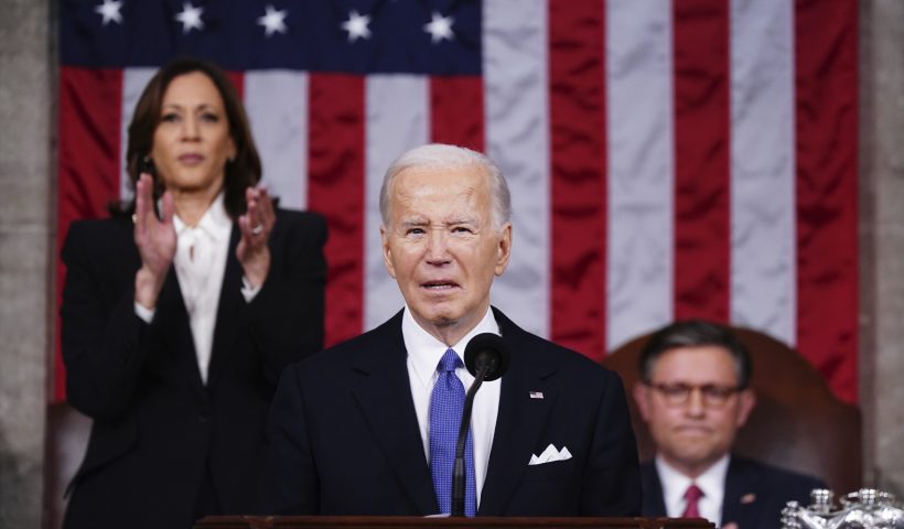 President Joe Biden delivers the State of the Union address to a joint session of Congress at the Capitol, Thursday, March 7, 2024, in Washington. Standing at left is Vice President Kamala Harris and seated at right is House Speaker Mike Johnson, R-La. (Shawn Thew/Pool via AP)