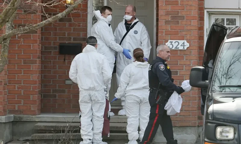 Members of the coroner’s office stand outside the scene of a homicide where six people were found dead in the Barrhaven suburb of Ottawa on Thursday, March 7, 2024. (Photo via AP/file)