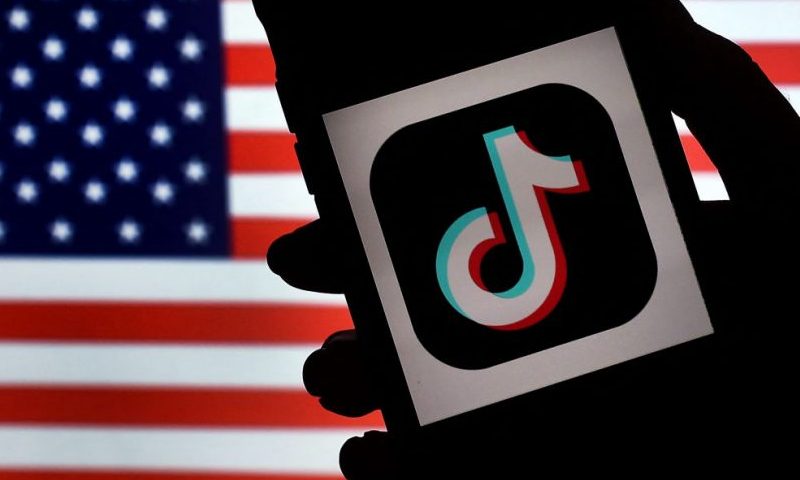 In this photo illustration, the social media application logo, TikTok is displayed on the screen of an iPhone on an American flag background on August 3, 2020 in Arlington, Virginia. - The US Senate voted on August 6, 2020, to bar TikTok from being downloaded onto US government employees' telephones, intensifying US scrutiny of the popular Chinese-owned video app. The bill passed by the Republican controlled Senate now goes to the House of Representatives, led by Democrats. (Photo by Olivier DOULIERY / AFP) (Photo by OLIVIER DOULIERY/AFP via Getty Images)