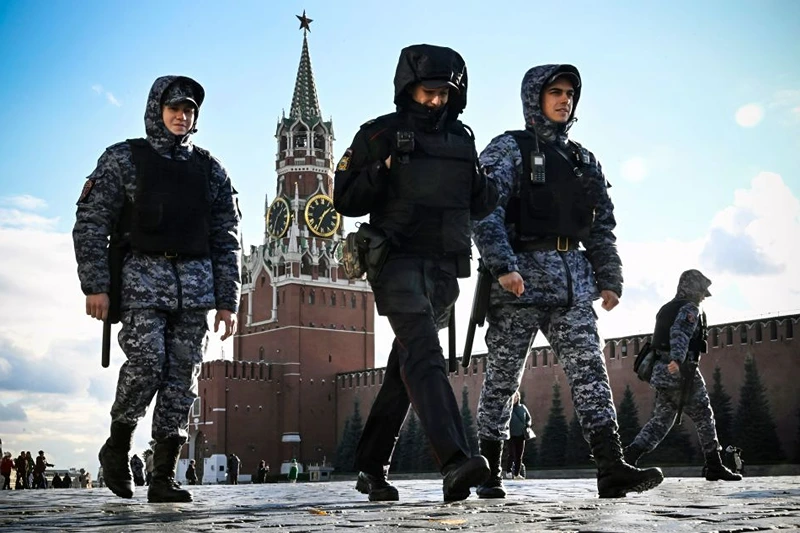 TOPSHOT - Police and the Russian National Guard (Rosgvardia) servicemen patrol Red Square in front of the Spasskaya tower of the Kremlin in Moscow on October 24, 2022, as part of security reinforcement measures. (Photo by Alexander NEMENOV / AFP) (Photo by ALEXANDER NEMENOV/AFP via Getty Images)
