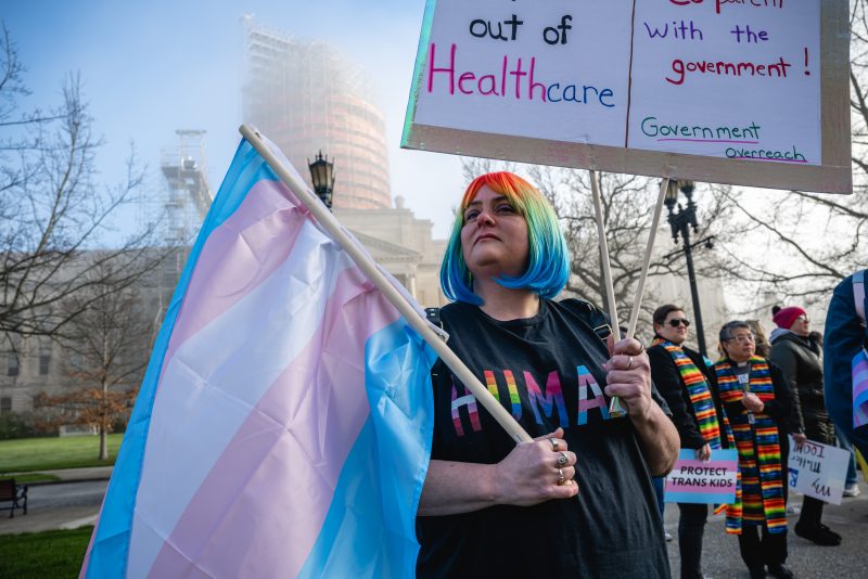 FRANKFORT, KY - MARCH 29: Sarah Newton stands with a trans pride flag during a rally to protest the passing of SB 150 on March 29, 2023 at the Kentucky State Capitol in Frankfort, Kentucky. SB 150, which was proposed by State Senator Max Wise (R-KY), is criticized by many as a 