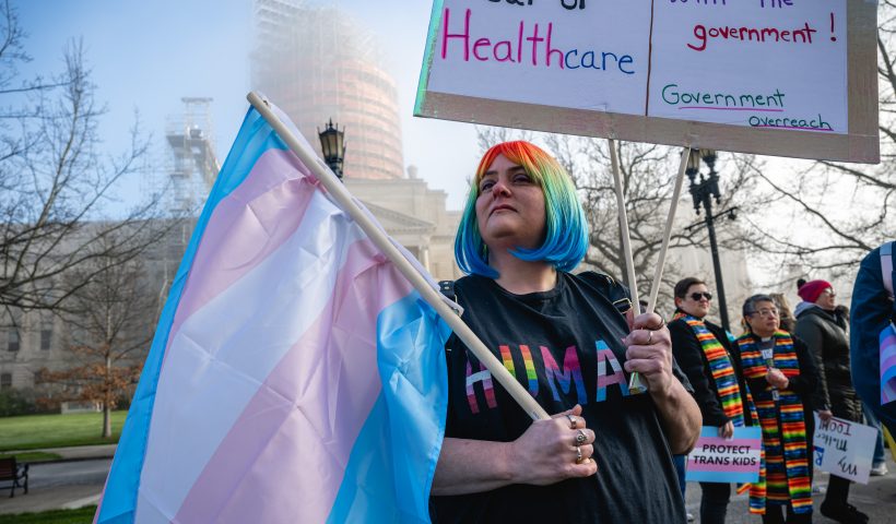 FRANKFORT, KY - MARCH 29: Sarah Newton stands with a trans pride flag during a rally to protest the passing of SB 150 on March 29, 2023 at the Kentucky State Capitol in Frankfort, Kentucky. SB 150, which was proposed by State Senator Max Wise (R-KY), is criticized by many as a "Don't Say Gay" bill and was vetoed by Kentucky Governor Andy Beshear during the General Assembly. Lawmakers may override this veto, passing the bill into law. (Photo by Jon Cherry/Getty Images)