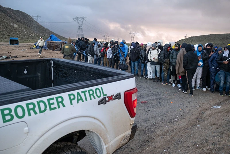 Asylum seekers wait in line to be processed by the Border Patrol at a makeshift camp near the US-Mexico border east of Jacumba, San Diego County, California.