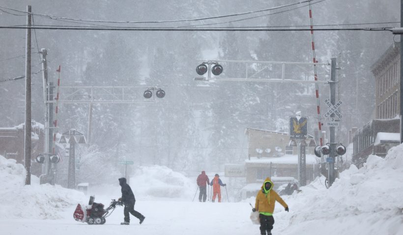 TRUCKEE, CALIFORNIA - MARCH 02: People make their way through downtown on foot and on skis as snow falls north of Lake Tahoe during a powerful multiple day winter storm in the Sierra Nevada mountains on March 02, 2024 in Truckee, California. Blizzard warnings were issued with snowfall of up to 12 feet and wind gusts over 100 mph expected in some higher elevation locations. Yosemite National Park is closed and a 50-mile stretch of Interstate 80 was shut down yesterday due to the storm. (Photo by Mario Tama/Getty Images)