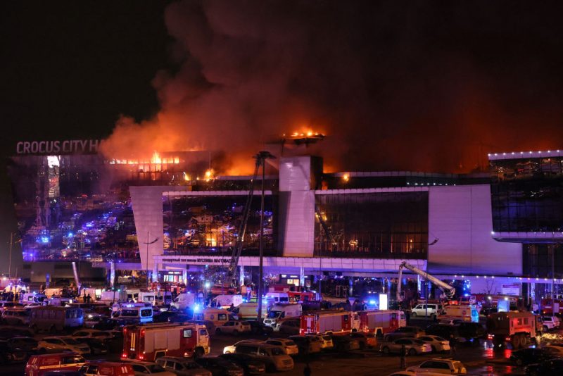 Emergency services vehicles are seen outside the burning Crocus City Hall concert hall following the shooting incident in Krasnogorsk, outside Moscow, on March 22, 2024. Gunmen opened fire at a concert hall in a Moscow suburb on March 22, 2024 leaving dead and wounded before a major fire spread through the building, Moscow's mayor and Russian news agencies reported. (Photo by STRINGER / AFP) (Photo by STRINGER/AFP via Getty Images)