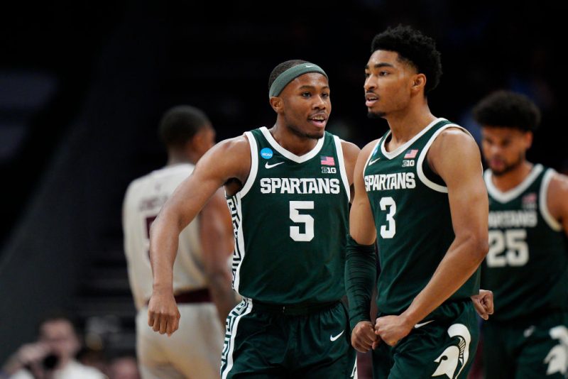 Tre Holloman #5 and Jaden Akins #3 of the Michigan State Spartans celebrate a basket against the Mississippi State Bulldogs during the second half in the first round of the NCAA Men's Basketball Tournament at Spectrum Center on March 21, 2024 in Charlotte, North Carolina. (Photo by Jacob Kupferman/Getty Images)