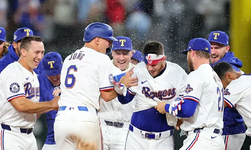 Jonah Heim #28 of the Texas Rangers is congratulated by teammates following a walk-off single in the 11th inning to defeat the Chicago Cubs in the Opening Day game at Globe Life Field on March 28, 2024 in Arlington, Texas. (Photo by Stacy Revere/Getty Images)