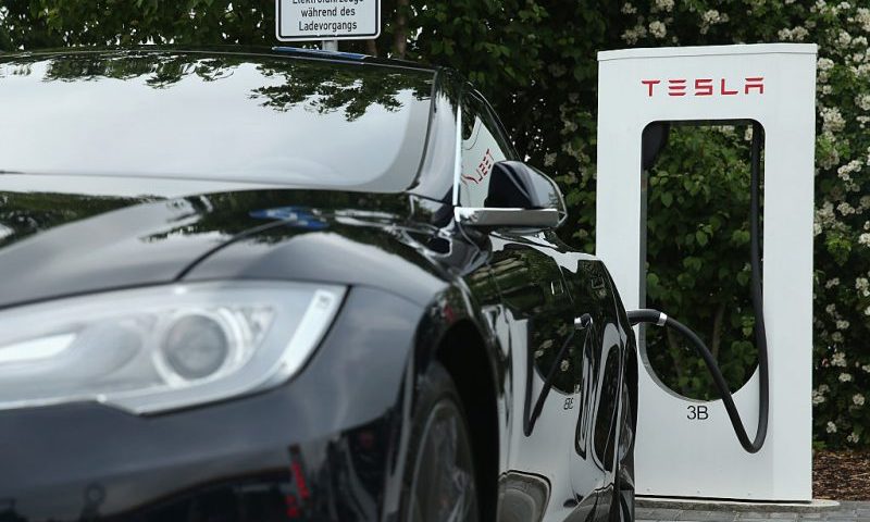RIEDEN, GERMANY - JUNE 11: A Tesla electric-powered sedan stands at a Tesla charging staiton at a highway reststop along the A7 highway on June 11, 2015 near Rieden, Germany. Tesla has introduced a limited network of charging stations along the German highway grid in an effort to raise the viability for consumers to use the cars for longer journeys. (Photo by Sean Gallup/Getty Images)