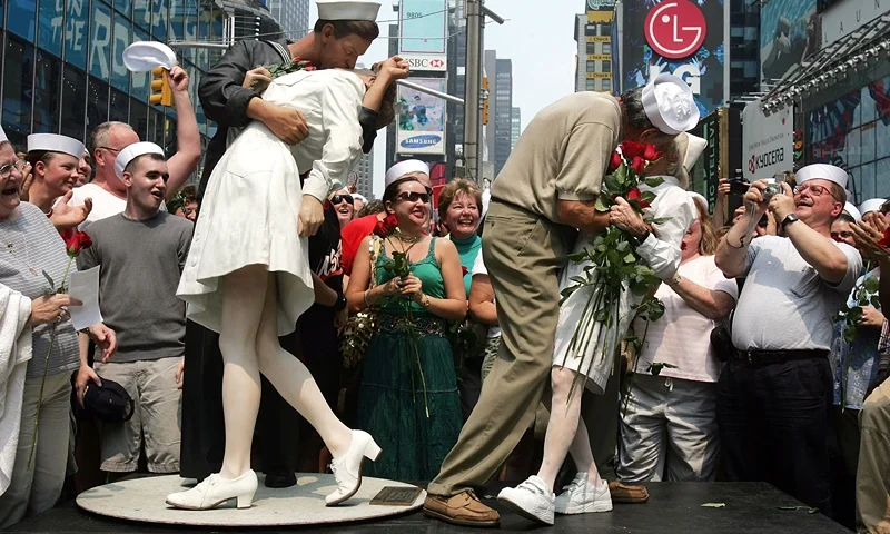 Times Square "Kiss In" Celebrates Famed WWII Photo NEW YORK - AUGUST 14: Carl Muscarello and Edith Shain, who claim to be the nurse and sailor in the famous photograph taken on V-J Day, kiss next to a sculpture based on the photograph in Times Square to commemorate the 60th anniversary of the end of World War II August 14, 2005 in New York City. Alfred Eisenstaedt took the famous photograph in Times Square but did not note the names of the people in the picture. (Photo by Mario Tama/Getty Images)
