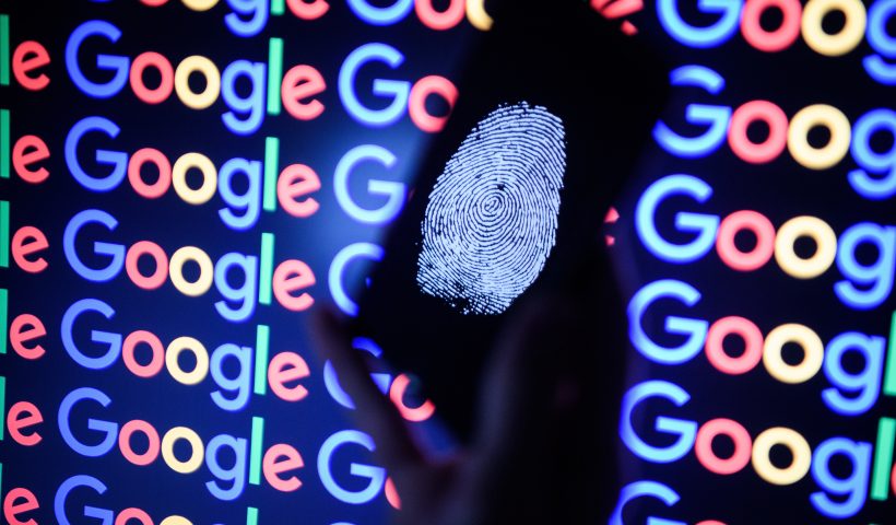 LONDON, ENGLAND - AUGUST 09: In this photo illustration, A thumbprint is displayed on a mobile phone while the Google logo is displayed on a computer monitor on August 09, 2017 in London, England. Founded in 1995 by Sergey Brin and Larry Page, Google now makes hundreds of products used by billions of people across the globe, from YouTube and Android to Smartbox and Google Search. (Photo by Leon Neal/Getty Images)