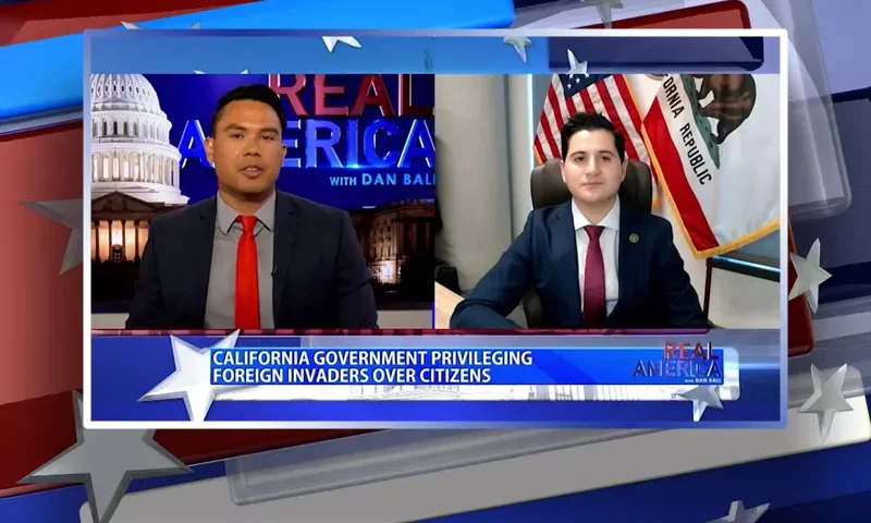 Video still from Real America on One America News Network showing a split screen of the host on the left side, and on the right side is the guest, Bill Essayli.