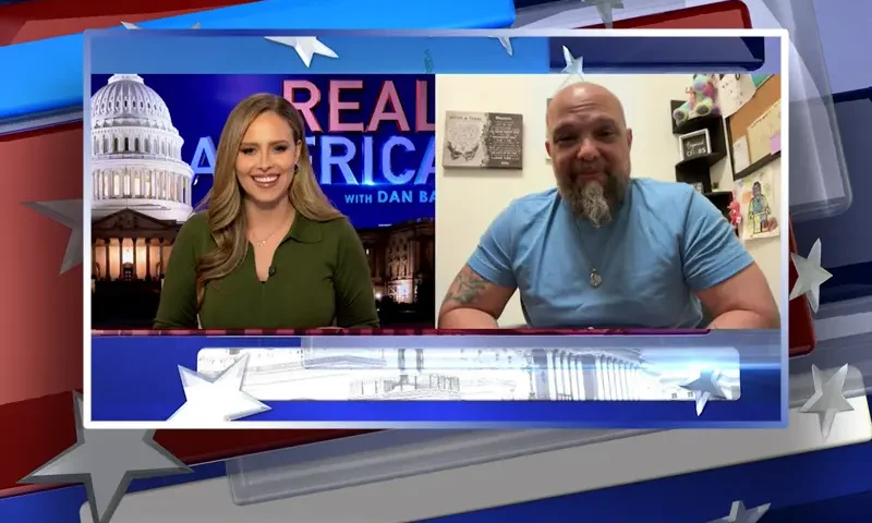 Video still from Real America on One America News Network showing a split screen of the host on the left side, and on the right side is the guest, Josh Macciello.
