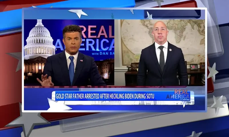 Video still from Real America on One America News Network showing a split screen of the host on the left side, and on the right side is the guest, Rep. Brian Mast.