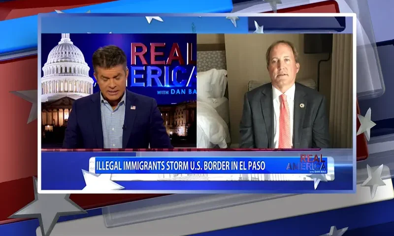 Video still from Real America on One America News Network showing a split screen of the host on the left side, and on the right side is the guest, Ken Paxton.