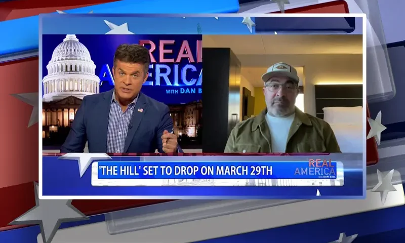 Video still from Real America on One America News Network showing a split screen of the host on the left side, and on the right side is the guest, Aaron Lewis.